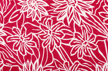 White floral pattern on red fabric. Graphic red flowers print as background.