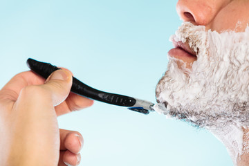 Man shaving with razor face profile