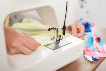 Successful young needlewoman is working with equipment