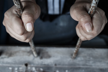 hands of jail holding prison bars