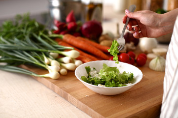 Cook's hands preparing vegetable salad - closeup shot