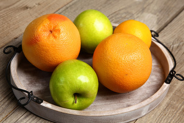Apples and oranges on old wooden background