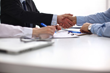 Business meeting at the table shaking hands conclusion of the