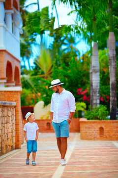 father and son walking on cute tropical street