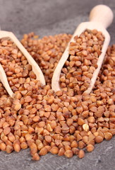 Buckwheat groats with spoon on cement structure