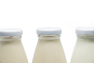 Three milk bottles focused on lid isolated