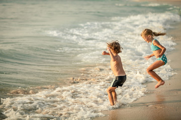 Two happy children  playing on the beach