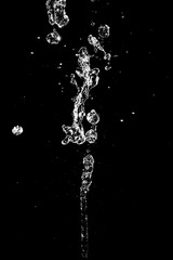 The large jet of water on a black background. Texture.