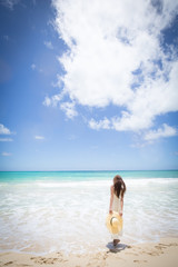 ハワイの海辺でリラックスする女性