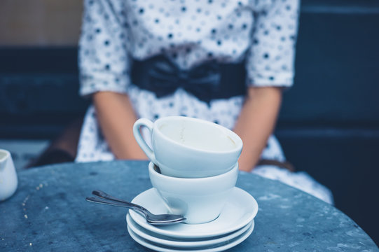 Woman at table with empty coffee cups