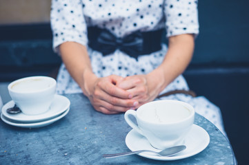 Woman at table with empty coffee cups