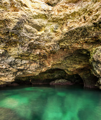 Beautiful sea cave and sun reflections on the rocks and in the water