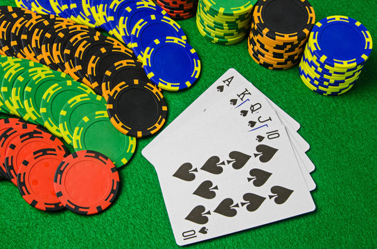 Playing cards 'royal flush' and chips on green background