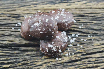 Small chocolate doughnuts on old wooden background
