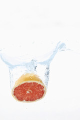 Grapefruit, die in Wasser vor weißem Hintergrund