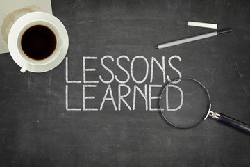 Lessons learned concept on black blackboard