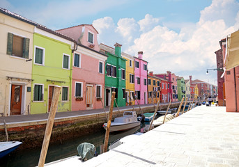Fototapeta na wymiar VENICE, ITALY, on APRIL 13, 2015. Burano island, multi-colored houses of locals. Cafe on the bank of the channel. Burano the island - one of attractive tourist objects in the Venetian lagoon
