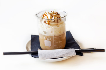 Cup of a fresh caramel latte with whipped cream on table in coff