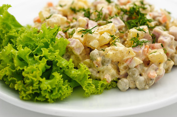 Olivie salad with mayonaisse isolated on white