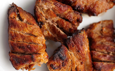 Pieces of grilled meat isolated on white