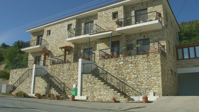 Two story masonry house in quiet resort town, establishing shot. Holiday villa