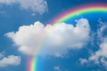Rainbow and White clouds in blue sky background
