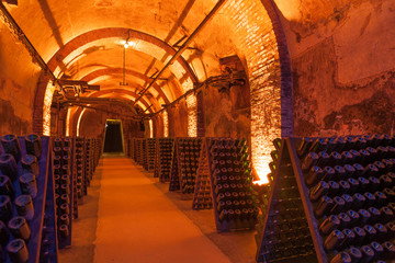 Rows of dusty champagne bottles in Reims cellar, France - 89160602