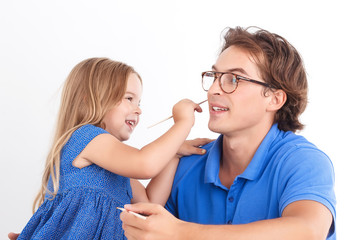 Happy daughter painting with father 