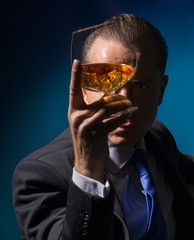 A man looks through the glass of cognac