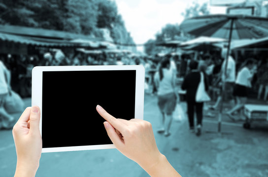woman hand holding the phone tablet on blur market background