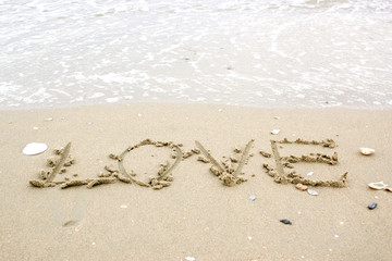 love word on beach with wave