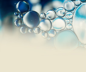 Abstract background with oil drops on water, macro with copyspace.