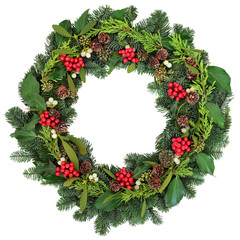 Traditional Christmas Wreath  with holly, ivy, mistletoe and winter greenery over white background.