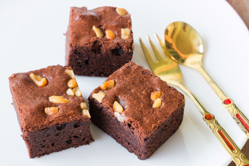 brownies and golden spoon with cup of coffee on table
