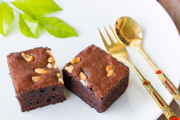 brownies and golden spoon with cup of coffee on table