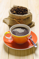 coffee cup and roast coffee in sack on wood table