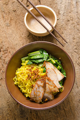Yellow noodles served with sliced pork