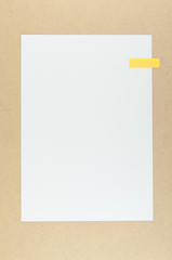 White paper with sticky note on particle board.
