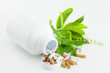 Herb capsule with green herbal leaf and bottle on white backgrou