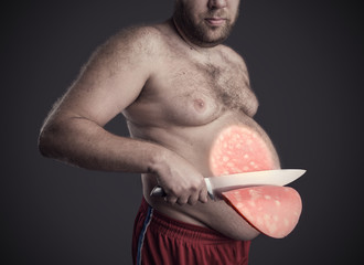 Man cuts a slice of sausage from his belly 