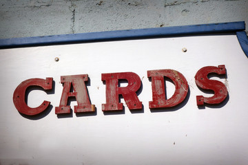 aged and worn vintage photo of cards sign on store