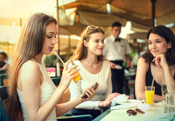 Three girls sitting at a cafe