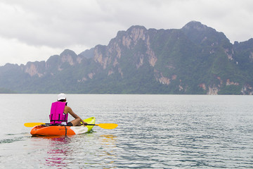 Young man paddling in Chiewlarn dam in Surat Thani, Thailand