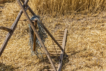 Old harvest tool, scythe and wooden rake.