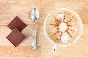 The cup of cappuccino with cinnamon abstratnym pattern