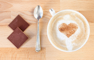 The cup of cappuccino with cinnamon heart