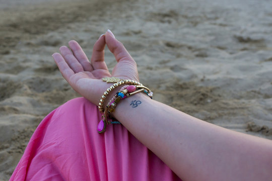 Om-Zeichen an Handgelenk einer jungen Yogi beim Yoga