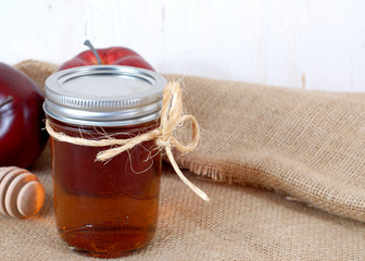Red apple and golden honey in rustic setting 