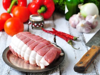 raw roast with vegetables and spices and sea salt on wooden table