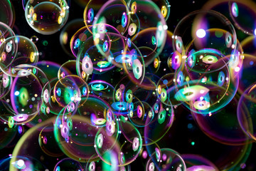 colorful soap bubbles flying around on black background